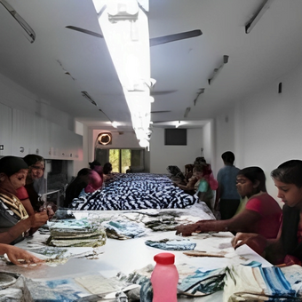 KK Fashion Exports factory workers finishing scarves on inspection table